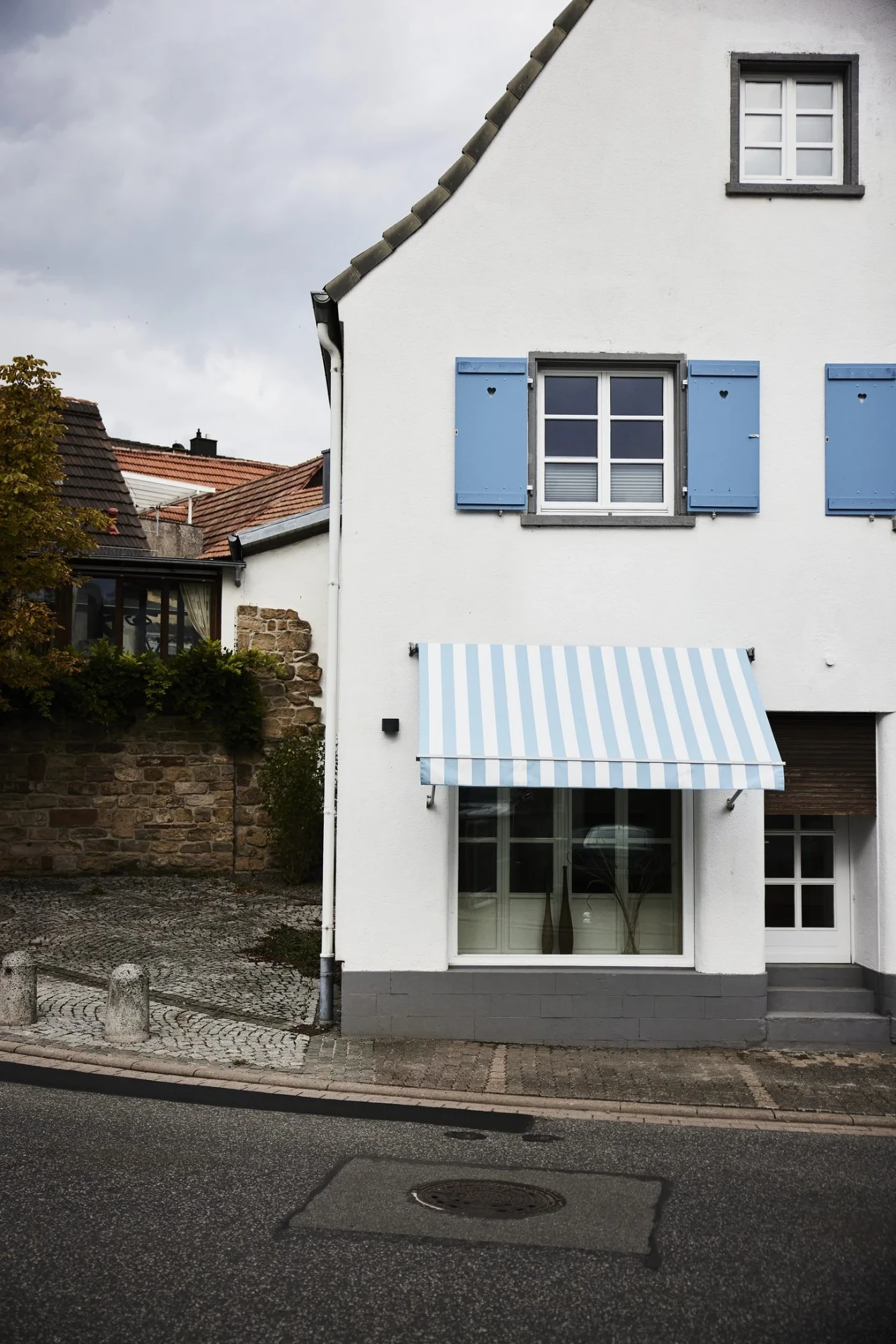 Historische Fassade der Alten Goldschmiede in Klingenmünster mit blau-weißem Markisen-Detail